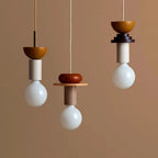 Nordic wooden pendant lights in orange and beige tones with white bulb and modern geometric shapes.