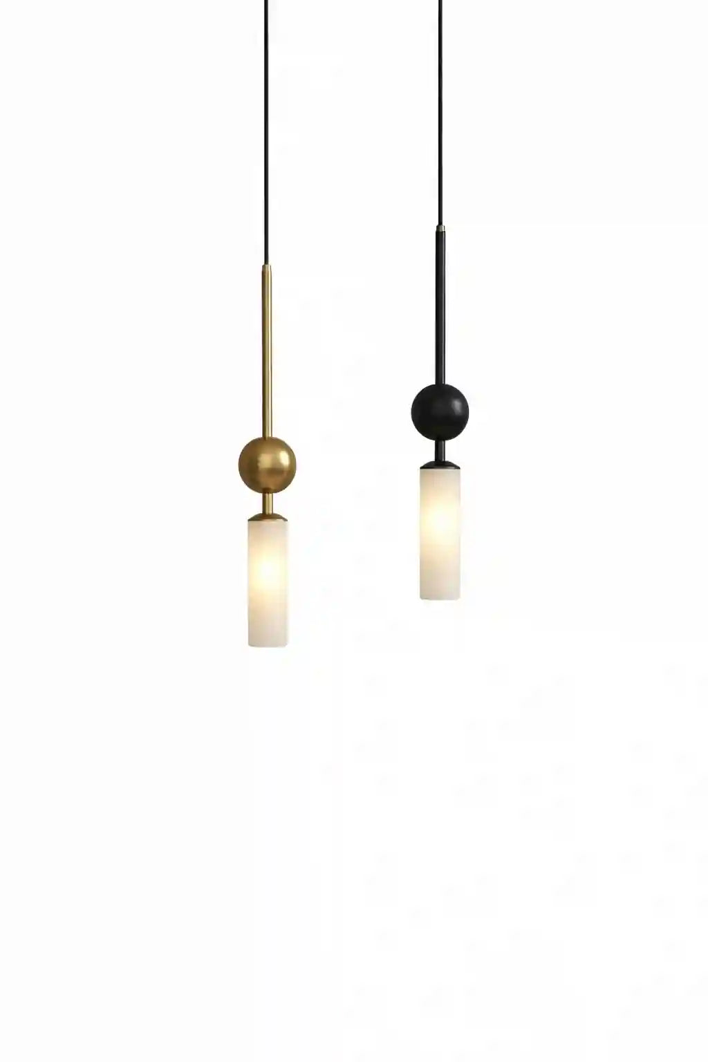 Two modern pendant lights with cylindrical frosted glass shades, one gold and one black with matching cords.